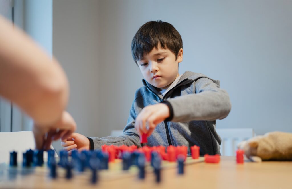 Strategy ideas concept for Kid playing board game with parent at