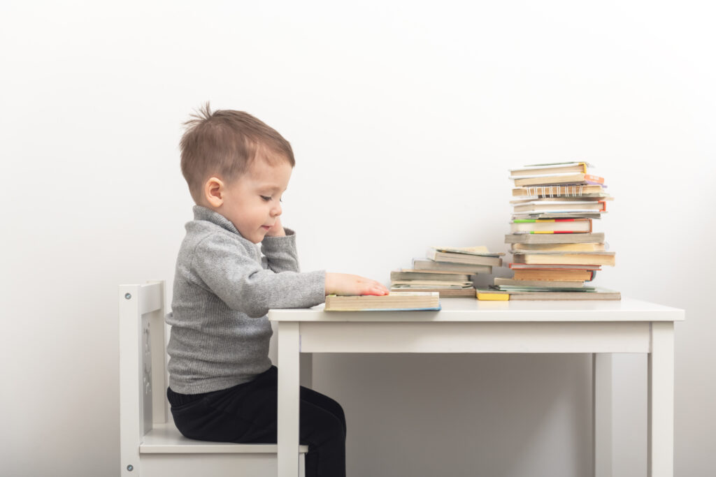Closeup of cute small boy reading books