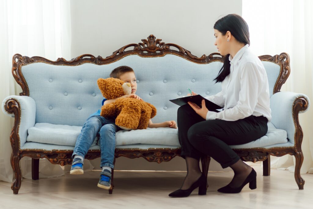 Child psychologist working with boy in office